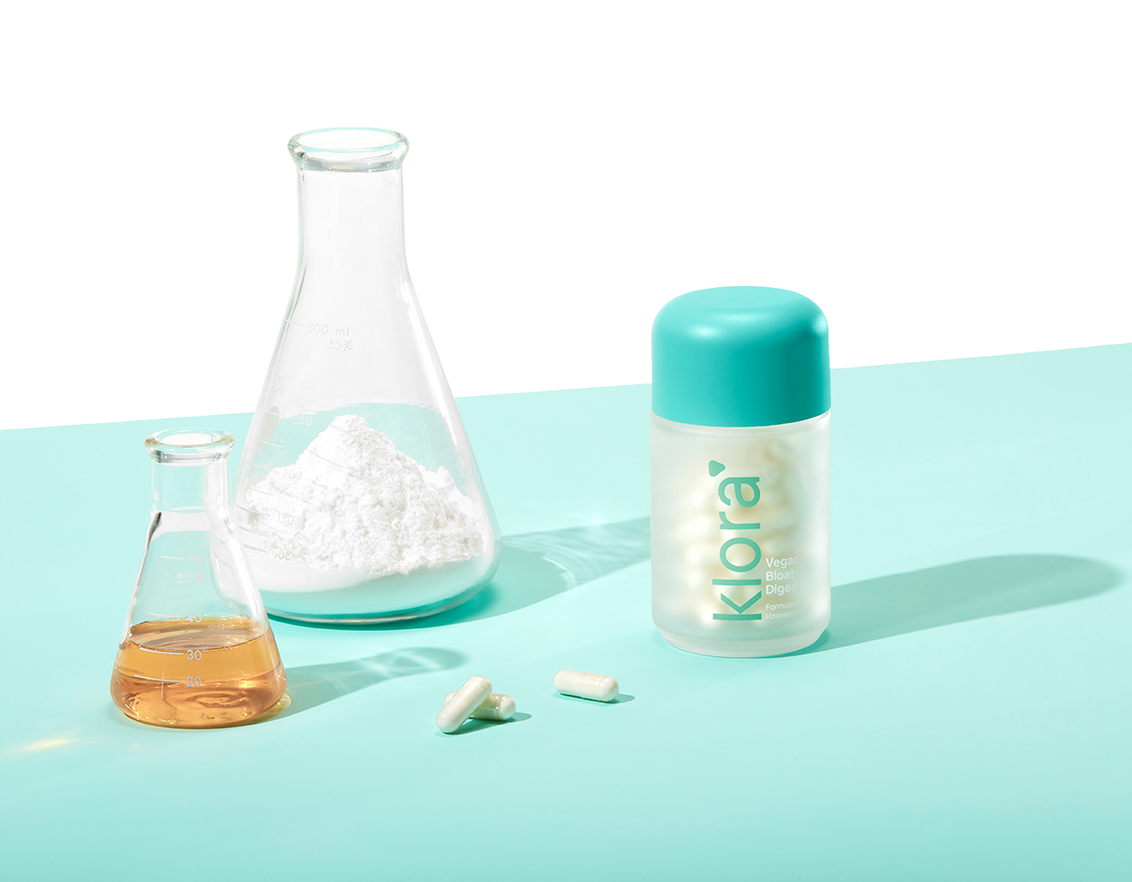 Klora Bloat-Digest Bottle next to science beakers 